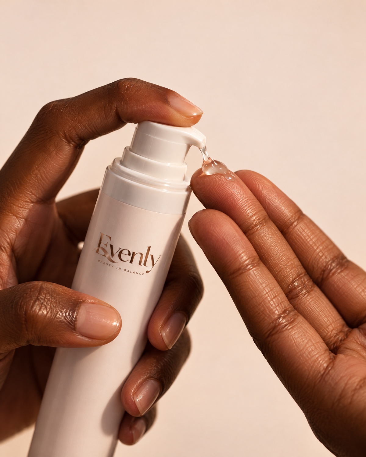 Hands with deep brown skin pressing the Evenly Night Cream pump, gel on fingertips