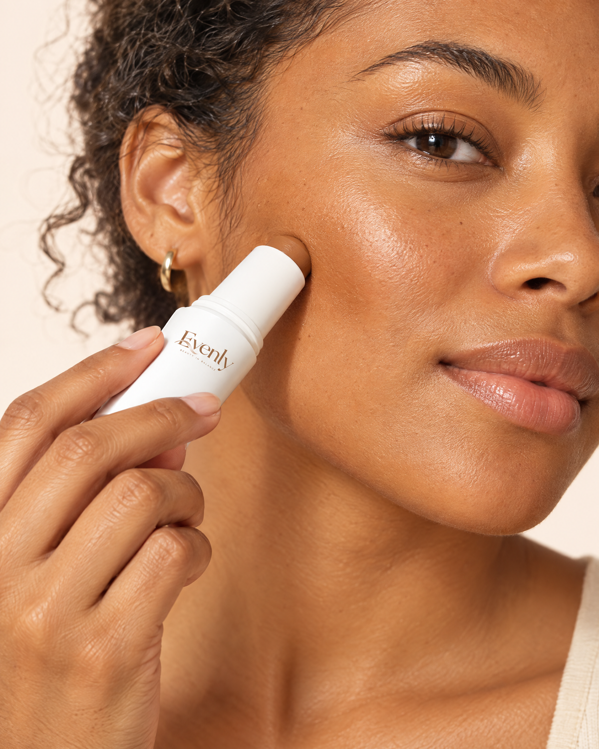 Close-up of the Evenly Day Stick being pressed into the cheek and blended